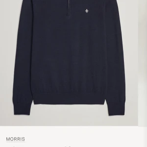 Mörkblå merinoullströja Morris half zip - Snygg mörkblå tröja från Morris i 100% merinoull med half zip och diskret logga på bröstet. Tröjan har ribbade muddar, lång ärm och en grå insida på kragen som ger en schysst kontrast. Perfekt för lager-på-lager och stilren look. Orginal pris 1799kr. Storleken är M men skulle säga att den känns som S-XS
