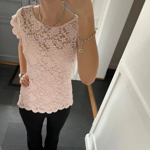 Rosa spetstopp  - Rosa kortärmad tröja i spets från Orsay i fint skick. Kan inte hitta storlek men skulle säga S, passar även M. Fastsytt tyg på insidan. Använd gärna köp nu!