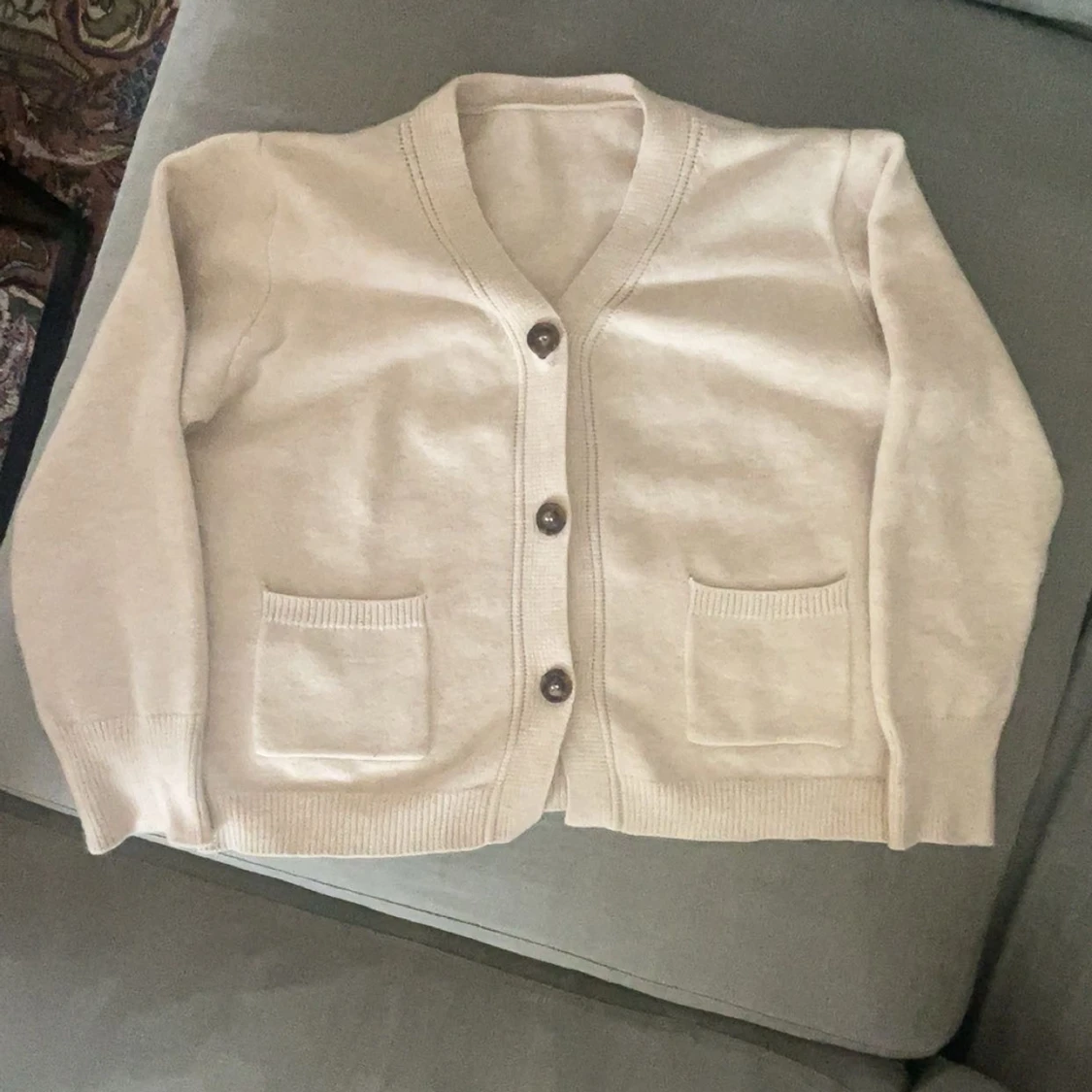 Beige kofta med knappar och fickor