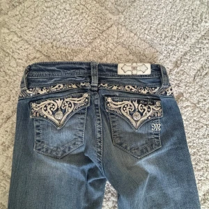 Miss Me jeans  - Sjukt snygga Miss Me jeans som är köpta på A2vintage. Byxorna är lågmidjade, bootcut och har snygga detaljer på fickorna. Dom är skonsamt använda men har ett litet hål sen innan längst nere vid foten. Ny pris ligger runt 1400kr. Säljer på grund av att dom blivit för korta. Det är bara att hör av er om ni vill ha fler bilder🌸