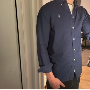 Ralph Lauren Skjorta - Tja säljer en Ralph lauren skjorta i färgen marinblå och i storlek M. Nypris 1595 KR mitt pris 299 KR. Inga defekter som hål eller fläckar. Skriv vid frågor eller funderingar.