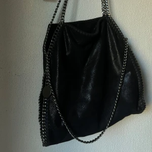 Väska - säljer denna snygga väska som påminner om Stella Mccartney, köpt i butik i göteborg för några år sedan, därav inget direkt märke. Ungefär 35x38 cm (skriv t mig om mer exakta mått). Använd några gånger, men fortfarande i bra skick 🖤
