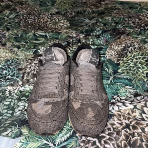 Valentino Rockrunners - Unika Valentino Garavani Rockrunner sneakers i grått och grönt med camouflagemönster. Skorna har snörning, rund tå och coola detaljer i ull och skinn. Bakpartiet är grönt läder och sulan har nitar för extra edge. Perfekta för dig som vill sticka ut. Man får inte med någon box eller sånt och en av anledningarna varför de är bra pris. Priset kan diskuteras vid snabb affär