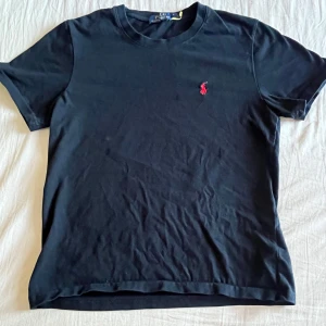 Polo Raplph Lauren t-shirt  - 🖤 Klassisk svart Polo Ralph Lauren t-shirt med röd logga 🏇 👕 Kortärmad | Unisex | Bekväm passform ✨ Perfekt basplagg för alla tillfällen  #PoloRalphLauren #RL #SvartTshirt #Logga #KlassiskStil #Streetwear #CasualOutfit #PreppyStyle #Herrmode #Dammode #UnisexFashion 🖤👟🎯