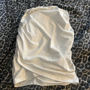 Vit kortkjol med snörning - Säljer en vit kortkjol med snygg rynkad snörning längs sidorna. Kjolen är gjord i mjukt bomullstyg och har en enkel, stilren look som är lätt att matcha med olika toppar. Perfekt för dig som gillar minimalistisk stil och vill ha något fräscht i garderoben.