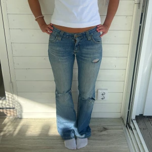 Jeans med hål - Ljusblå jeans med hål från Lee. Storlek: XS, midja: 35x2 cm innerben: 80 cm. Har slitage vid foten som synd i sista bilden 