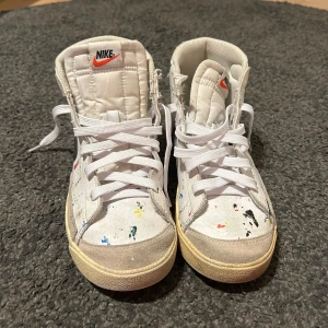 Nike blazers  - Unika och trendiga Nike Blazer med paint splatter-design – perfekt för dig som gillar Streetwear med karaktär! Skorna är i okej skick, använda men fortfarande fullt funktionsdugliga. Visst slitage finns (se bilder), men inget som påverkar användningen. En snygg och ovanlig modell som sticker ut.