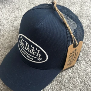 Mörkblå Von Dutch keps - Snygg mörkblå keps från Von Dutch med klassisk vit broderad logga framtill. Kepsen har justerbar passform. Helt ny, endast testad! Nypris 399!