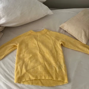 Gul stickad tröja från Selected Femme -  Orginal pris:600kr Supermjuk gul stickad tröja från Selected Femme med rund halsringning och långa ärmar. Tröjan har en avslappnad passform och är tillverkad i en ullblandning med minst 20% alpackaull för extra mjukhet. Och aldrig andvänd då lappen finns kvar!