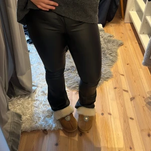 Svarta skinnbyxor med bootcut - Snygga svarta skinbyxor med bootcut nertill. De har en tight passform upptill och släpper ut lite vid benslutet.💕