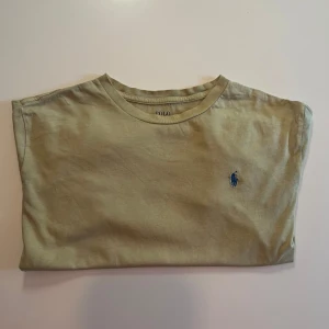 Gul  t-shirt från Polo Ralph Lauren - Snygg beige  t-shirt från Polo Ralph Lauren i mjuk bomull.  Tröjan är storlek Xl men sitter som ett L eller en stor M. Varan är äkta såklart. Kan mötas i Sthlm eller frakta 🚚 