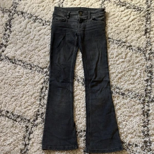 Svarta bootcut jeans från RYVLS - Snygga lågmidjade svarta jeans från RYVLS med bootcut passform och coola stjärnknappar❤️ Jeansen har fickor fram och bak och  är i mycket bra skick ❤️ 