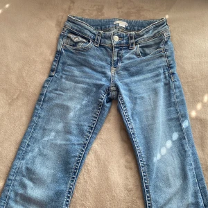 Blå bootcut jeans från Gina Tricot - Snygga blå bootcut jeans från Gina Tricot. 💗Jeansen har klassiska fickor med knapp bak, utsvänga nertill. Perfekt för dig som vill ha ett par snygga byxor till hösten. Tyvärr har den slitits lite längst ner på byxorna som man kan se på en av bilderna men de är bara på ena sidan. 