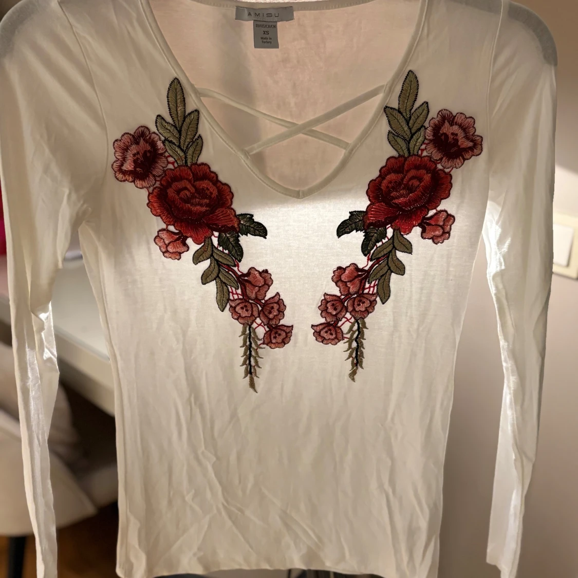 Vit långärmad topp med broderade blommor