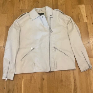 Missguided white jacket, size 36 small good condition - Vit jacka skinnimitation med dragkedja fram och detaljer som axelklaffar och fickor med dragkedja. Jackan har en klassisk biker-stil med en modern twist.