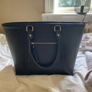 Svart handväska - Jättesnygg i superbra skick. Svart med gulddetaljer. 2 innerfack. Perfekt till skolstarten🏫🎓Väldigt rymlig