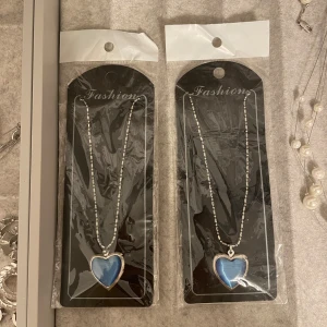 Nytt halsband med blått hjärthänge - 2 st snygga nya halsband med silver kedja och ett blått hjärta som kan öppnas och sättas in bild i (se bild 3). Perfekt som kompis halsband och en fin present! 