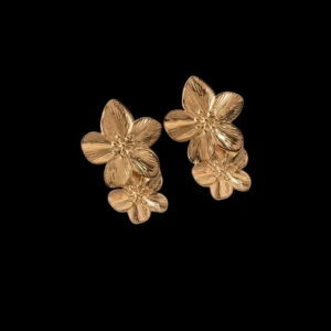 Guldiga blommiga örhängen - Supersnygga örhängen i guldton med tre blommor i olika storlekar på varje örhänge. De har en detaljerad, texturerad yta som ger ett lyxigt intryck och passar perfekt för dig som vill sticka ut med en unik accessoar.