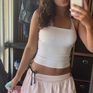 Vit tube top - Säljer en vit croppad linnetopp och ribbad struktur. Toppen har en enkel och clean look som är perfekt för varma dagar.  Superenkel att matcha med allt!