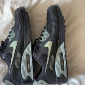 Nike Air Max 90 Gore-Tex sneakers - Säljer ett par svarta Nike Air Max 90 Gore-Tex sneakers med ljusgrå detaljer och swoosh. Skorna har en chunky siluett, synlig Air-enhet i sulan och snörning. Materialmix av skinn och syntet med vattentät Gore-Tex-panel. Perfekt för dig som gillar streetwear och vill ha något unikt. Pris går diskutera 