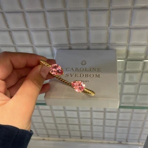 Guldarmband med rosa stenar Caroline Svedbom - Supersnyggt guldarmband från Caroline Svedbom, knappt använt och säljer då detta nu