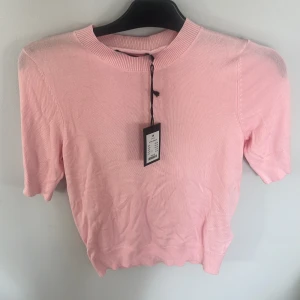 Ljusrosa stickad tröja XS - Supersöt ljusrosa stickad tröja med korta ärmar och rund hals. Tröjan är ganska tunn. Är i XS men passar även S och M då den är lite stor skulle jag säga. Passar perfekt till jeans eller kjol. Ribbad kant vid hals, ärmslut och nederkant. Aldrig använd och har prislapp kvar. Pris kan diskuteras!!