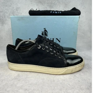 Lanvin cap toe sneaker - – Condition: 8/10  - Size: 45/UK11  – What is included:  Box, dustbag  – Retail price: 6000 + SEK  Please note that Lanvins fit big and our recommendation is to go one size down