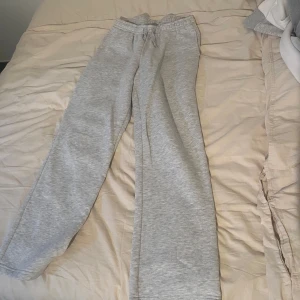 Grå mjukisbyxor med snörning - Säljer ett par grå mjukisbyxor med dragsko i midjan och raka ben från Gina Tricot. Perfekta för chill dagar eller när du vill vara extra bekväm. Mjukt material och enkel stil som funkar till allt.