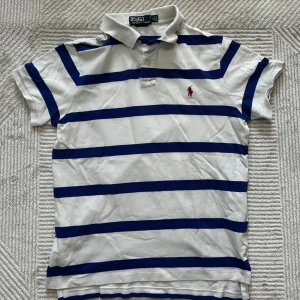 Ralph lauren piké | M - Vit, blå randig Ralph lauren piké | mycket fint skick men defekter förekommer ( se bilder ) inget som påverkar helheten | om du har några funderingar tveka då inte på att höra av dig | ⚜️
