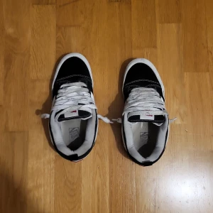 Svarta och vita Vans Old Skool sneakers - Pris kan diskuteras. Klassiska Vans Old Skool sneakers i svart och vitt med den ikoniska vita sidoremsan. Skorna har vit sula, svarta ovandelar i mocka och canvas, samt vita snören. Perfekta för en streetwear-look och passar till det mesta. Snygg kontrast med vita sömmar och detaljer.