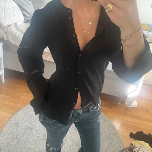 Svart skjorta med knappar och spetsdetalj - Snygg svart skjorta med knappar framtill och diskreta spetsdetaljer på ärmarna. 🙌🙌