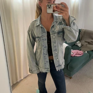  ljusblå jeansjacka  - Säljer en oversized ljusblå jeansjacka från H&M med slitna detaljer och rå kant nertill. Jackan har klassisk krage, knappar framtill och två bröstfickor med lock. Perfekt till sommar och tidig höst🩵🩵