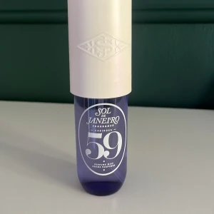 Sol de Janeiro Cheirosa 59 Perfume Mist - Fräsch och trendig parfymmist från Sol de Janeiro i modellen Cheirosa 59. Flaskan är lila med vit text och har en stilren, rundad form. Locket och spraymunstycket är i krämvitt plastmaterial. Perfekt för dig som gillar snygg design och vill dofta gott hela dagen. Jag har använt den kanske två eller tre gånger så de har försvunnit lite lite men det finns bild på. Annars så är den fräsch och ganska ny.