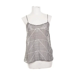 Mönstrad linnetopp från ASOS - Snygg och luftig linnetopp från ASOS i svartvitt randigt mönster med tunna axelband. Toppen har en lös passform och är perfekt för varma dagar. Mönstret är grafiskt med diagonala och vertikala ränder som skapar en cool look.