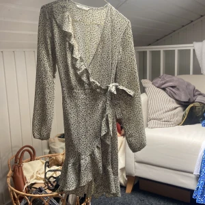 Omlottklänning med volang  - Grön omlottklänning med vita och svarta prickar från ONLY.  Använd fåtal gånger. 