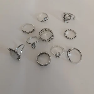 10-pack silverfärgade ringar - Säljer ett set med 10 silverfärgade ringar med  olika former och mönster. Perfekt för att mixa och matcha på flera fingrar för en cool look.