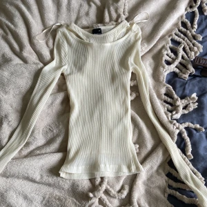 Vit ribbad långärmad topp Gina Tricot - Säljer en superfin vit ribbad långärmad topp från Gina Tricot i storlek XS. Toppen är tight, har en ”insyddt” linne och är i ett tunt, stretchigt material som är lite genomskinligt. Perfekt att styla med jeans eller kjol för en trendig look. Aldrig använt 