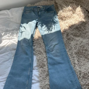 Ljusblå bootcut jeans från Zara - Säljer ett par ljusblå jeans från Zara med klassisk femficksmodell och bootcut-ben. Jeansen har normal midja, bälteshällor och dragkedja med knapp. Tillverkade i mjukt denimtyg som ger en avslappnad vibe.
