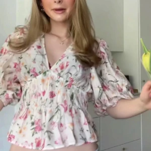 Blommig blus med puffärm och v-ringning - Supersöt blommig blus från hm i vitt med rosa och gröna detaljer. 