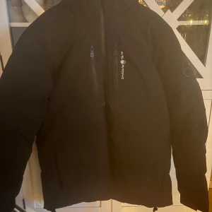 Svart jacka från Sail Racing - Säljer en svart jacka från Sail Racing med dragkedja och huva. Riktigt bra när det är lite kyligare väder. Jag säljer jackan på grund av att den är för stor för mig. Kontakta för frågor😃