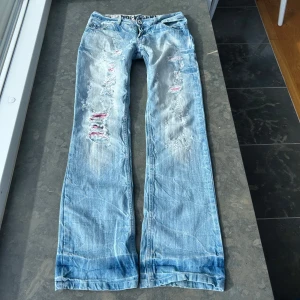 Y2k jeans  - Så himla coola jeans med slitningar. Lågmidjade. Innerbenslängd 77 cm. Midjemått: 38 cm midjehöjd:19 cm. Skriv om ni vill ha bild på hur jag har mätt. Har ingen bild på då de tyvärr inte passar💕