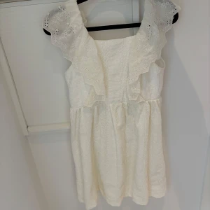 Vit klänning med spetsdetaljer från Zara  - Charmig vit klänning med vackra spetsdetaljer och volanger på axlarna. Inte använd my leg och har därför ett väldigt bra skick. Meddela vid frågor eller fler bilder
