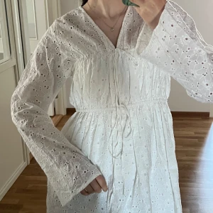 Vit klänning  - Söt vit klänning från NA-KD med broderade detaljer och knytdetalj framtill. Perfekt för studentklänning eller till sommaren. Den är helt ny med prislappen och aldrig använt. Ordpris 599kr. För mer frågor och bilder kontakta mig💕