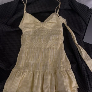 Gul rutig klänning - Söt gul rutig klänning med smala axelband och volangdetaljer. Perfekt för varma sommardagar. Den har en smickrande passform med en lätt och luftig känsla.