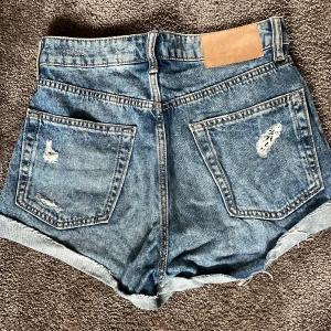 Jeansshorts - Snygga blå jeansshorts med slitningar och uppvikta kanter.💙