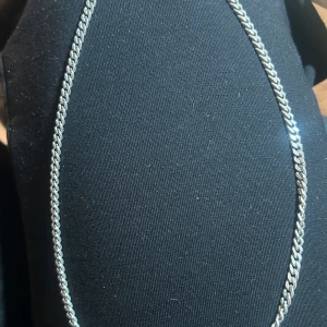 Silverfärgat halsband i 925 silver - Snyggt och stilrent halsband i silverfärgat 925 silver. Kedjan har en klassisk design med en fin länkstruktur och är märkt med 925 för äkthet. Perfekt för att ge en elegant touch till din outfit.