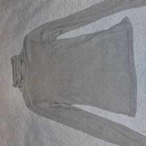Grå glittrig tunn  polotröja  st S - Snygg grå polotröja med glittrande detaljer. Perfekt för att lysa upp din garderob. Tröjan har långa ärmar och en bekväm passform. Mkt fint skick 