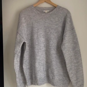 Grå stickad tröja från Gina Tricot - Mysig grå stickad tröja från Gina Tricot i bra skick!❣️ Perfekt för sena kvällar med sin mjuka och bekväma passform. Tröjan har långa ärmar och ribbade kanter vid ärmslut och nederkant. Storlek 170, jag som brukar har storlek S tycker den är overzised så passar en M också!🤩