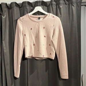 Rosa tröja  - Säljer en söt rosa tröja med broderade rosor på. Tröjan är croppad och har långa ärmar, perfekt för en trendig look. Passar bra till både jeans och kjol. Skriv gärna om eventuella frågor.🌸🌷