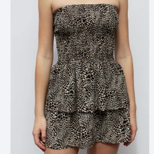 Mönstrad kjol från Subdued - Trendig klänning från Subdued i storlek XS med ett unikt hjärtmönster(leopard mönster) i svart och beige. Klänningen har en volangdetalj som ger en lekfull touch. Perfekt för att skapa en stilfull look. LITEN I STORLEKEN  